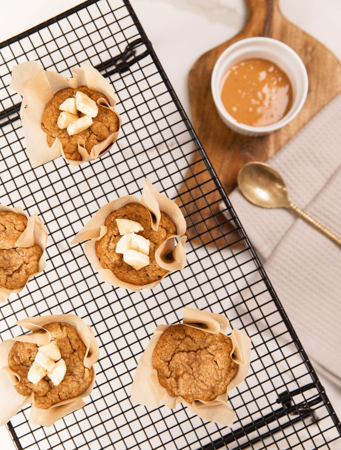 Freshly baked Banana Protein Muffins on a cooling rack.
