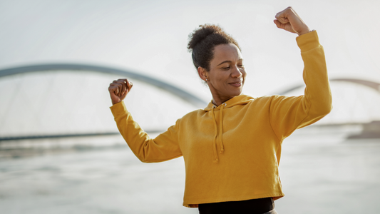 A woman flexing as she runs.