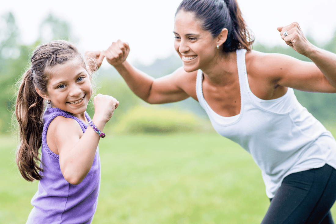 A woman and a girl flexing, showing their muscles and how strong they are.