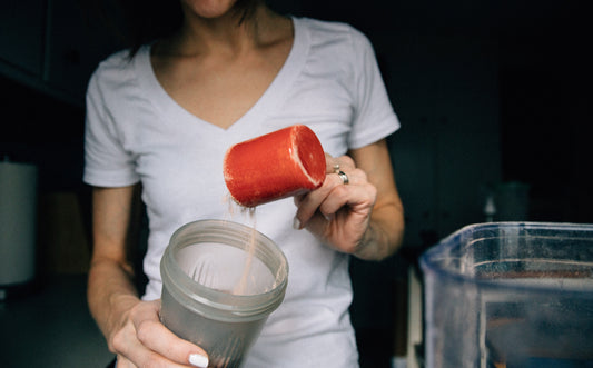 A woman scooping protein powder.