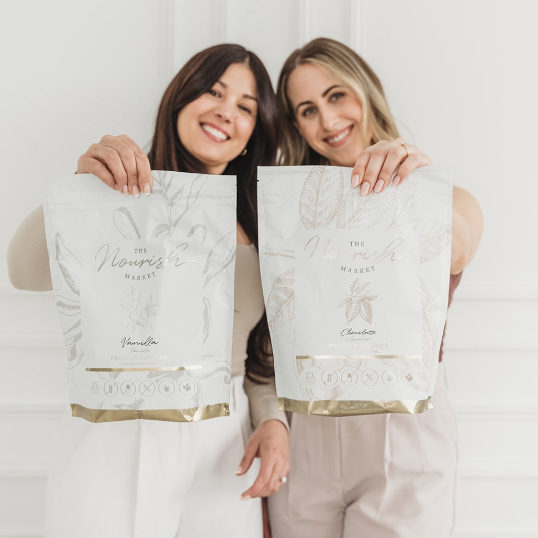 Two women holding up a bag of vanilla and chocolate protein powder.