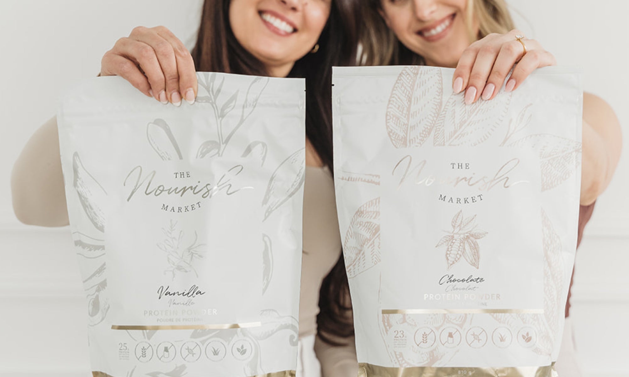 The founders holding up the Nourish Market Vanilla and Chocolate Protein Powder. 